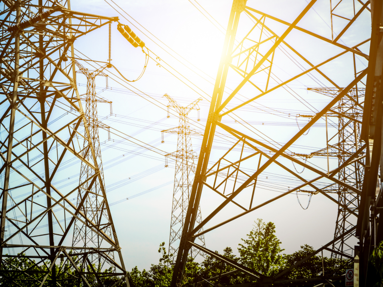 Power transmission tower with warm sunlight flare