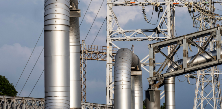 Industrial chimneys and metal piping with overhead cables