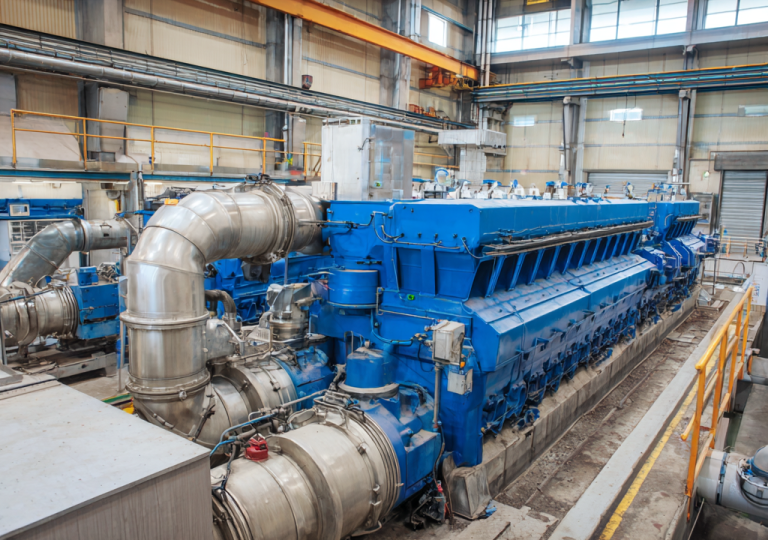 Large blue turbine-generator equipment inside a power plant